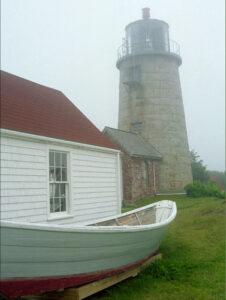 Boat and lighthouse in the fog in Maine